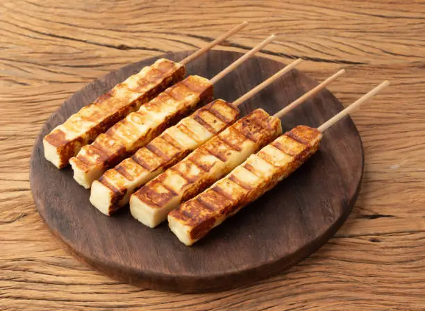 Grilled Rennet or Coalho cheese on a wooden board.