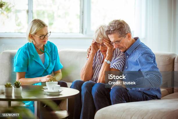 Nurse Talking With Worried Senior Couple Stock Photo - Download Image Now - Bad News, Cancer - Illness, Crying