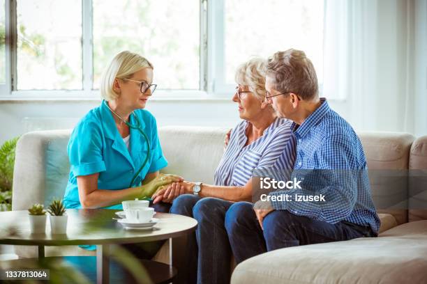 Worried Senior Couple Talking With Nurse Stock Photo - Download Image Now - Bad News, Cancer - Illness, Nurse