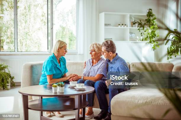 Worried Senior Couple Talking With Nurse Stock Photo - Download Image Now - 70-79 Years, Adult, Assisted Living