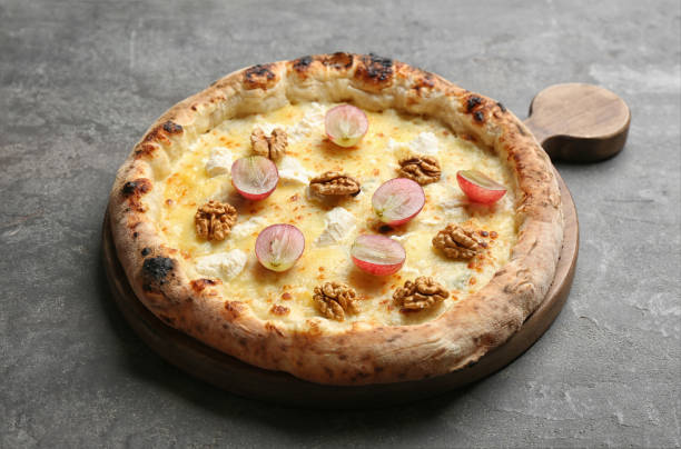 istock Delicious cheese pizza with walnuts and grapes on grey table 1337817016