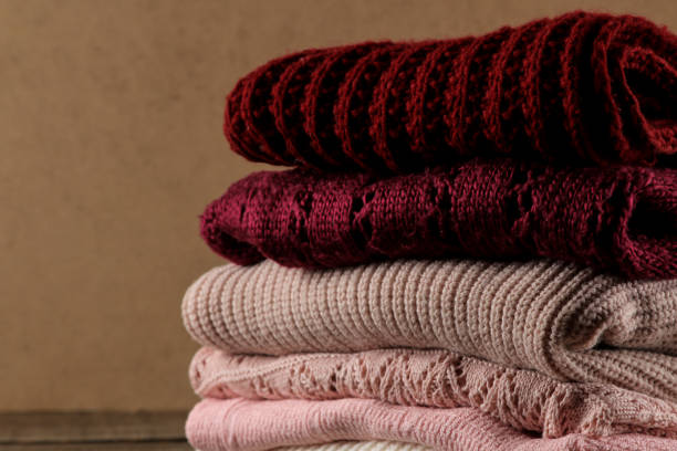 istock Autumn composition with various warm sweaters piled on a brown wooden background 1337822042