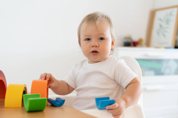 istock Blond blue-eyed baby playing with plastic geometric figures. Child motor development at kindergarten 1337823897