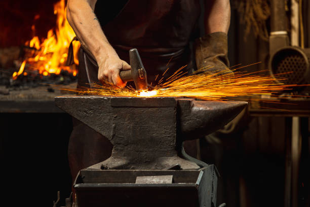 nahaufnahme arbeiten mächtige hände eines männlichen schmieds schmieden ein eisenprodukt in einem schmied. hammer, rotes heißes metall und amboss. arbeitsbegriff, retro-berufe - blacksmith stock-fotos und bilder