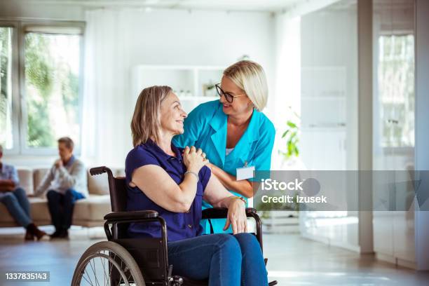 Friendly Nurse Consoling Senior Woman Stock Photo - Download Image Now - Social Services, Adult, Disability