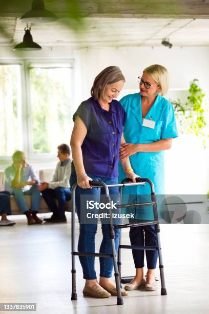 Nurse Helping Senior Woman To Use Walking Frame Stock Photo - Download Image Now - Parkinson's Disease, Patient, Nurse