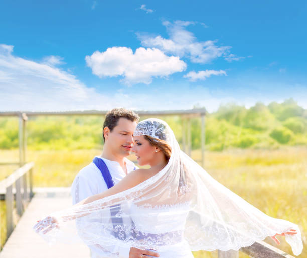 Couple in wedding day outdoor with wind on veil