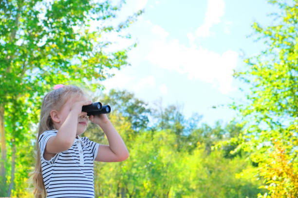 istock Little girl using binoculars in the forest. Exploring the world. 1337841562