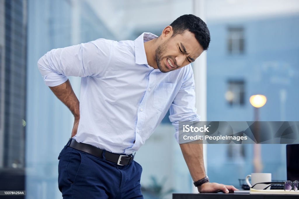 Shot of a businessman suffering from backache at work The importance of a good office chair Backache Stock Photo