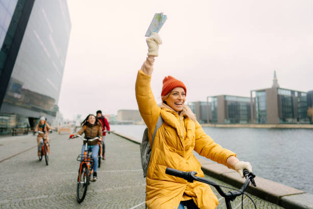 travel guide and her group on the bicycles through the town - white denmark nordic countries winter imagens e fotografias de stock