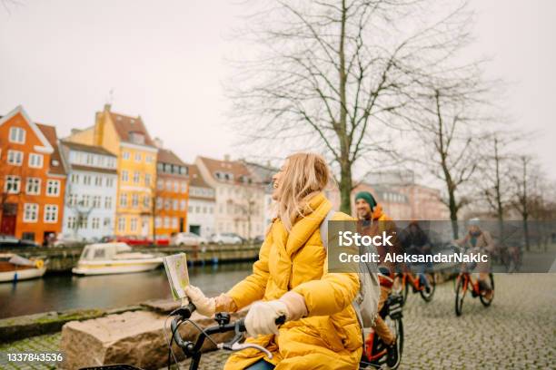 Travel Guide And Her Group On The Bicycles Through The Town Stock Photo - Download Image Now