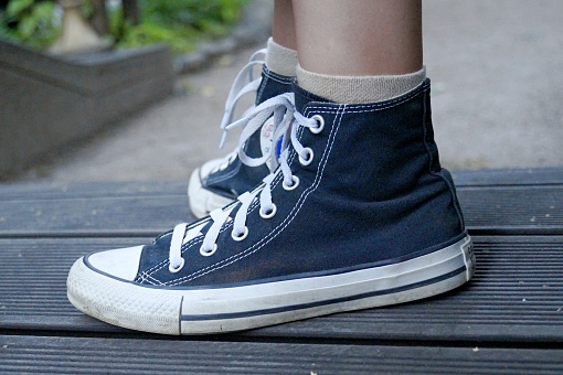 Feet in sneakers on the girl's feet. High quality photo