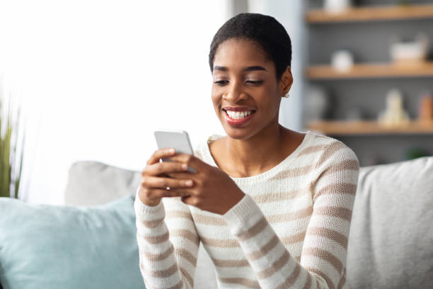 istock Mobile Communication. Positive Young Black Lady Messaging On Smartphone At Home 1337849401