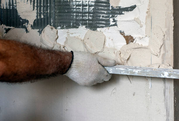 istock Plastering walls using gypsum plaster and rules. The worker levels the plaster with a leveler. 1337849952