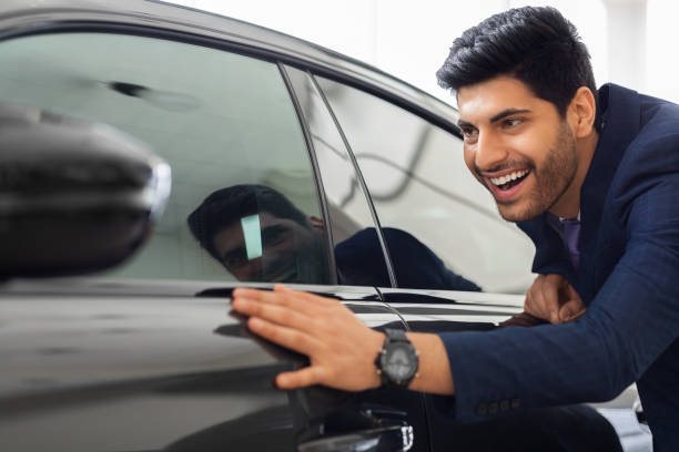 istock Excited middle-eastern businessman touching brand new car 1337853986