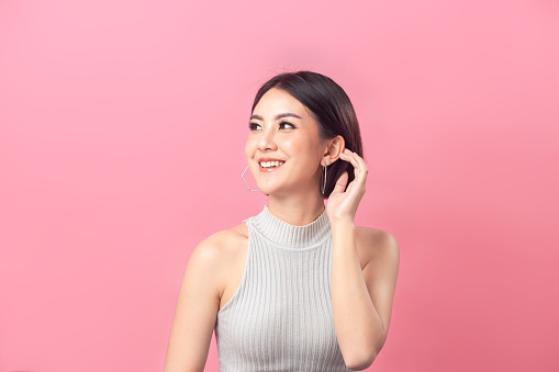 Beautiful Asian woman short hair smiling in studio pink background.