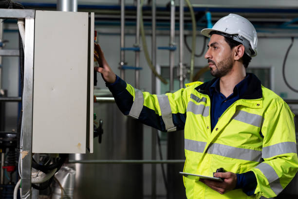 istock Technicians male worker working with digital tablet. Engineering male worker repairing, maintenance and checking the operation of equipment in the industrial factory, wearing safety uniform and helmet 1337856085