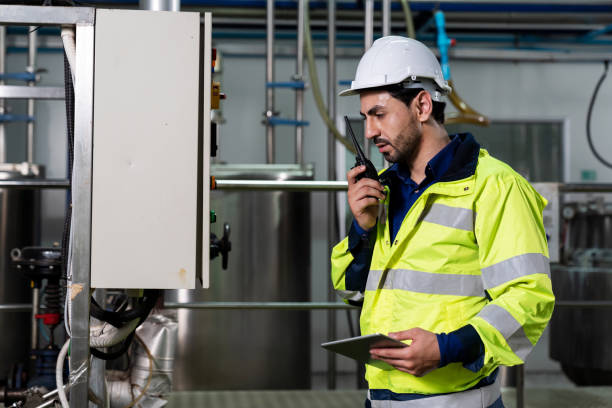 istock Technicians male worker working with digital tablet. Engineering male worker repairing, maintenance and checking the operation of equipment in the industrial factory, wearing safety uniform and helmet 1337856088