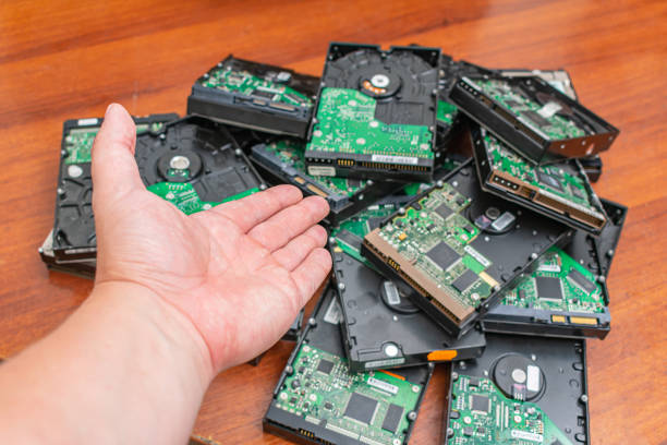 A bunch of old and dusty hard drives pointed to by a data recovery wizard