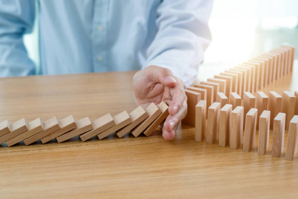 istock Businessman hand stop domino effect 1337857828