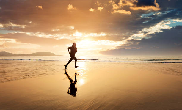 istock Man running on the golden beach 1337858038