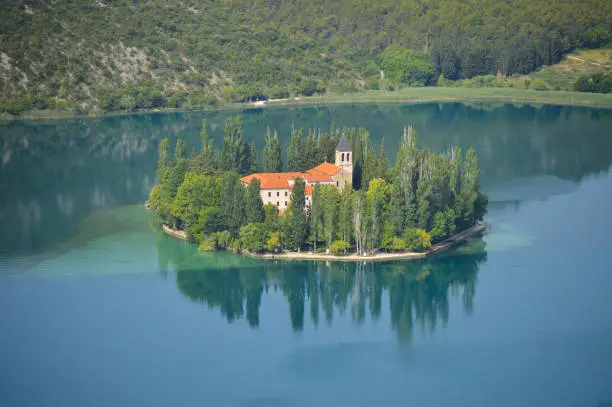 Visovac Island is among the most important natural and cultural values of the Republic of Croatia. Since 1445, this has been the site of the Franciscan monastery of Our Lady of Mercy, and the Church of Our Lady of Visovac. With their magnificent grounds and surrounded by Visovac Lake, this forms a unique entity. During its stormy history, Visovac was and has remained an island of peace and prayer, and the Franciscan monastery is a fortress of spirituality and faith, and one of the key foundation stones of the survival of the Croats and the preservation of the Croatian national identity. The monastery possesses a significant archaeological collection, a collection of historical church linens and dishes, and a rich library with many valuable books and incunabula.