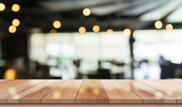 istock Empty wooden table top with lights bokeh on blur restaurant background 1337869849