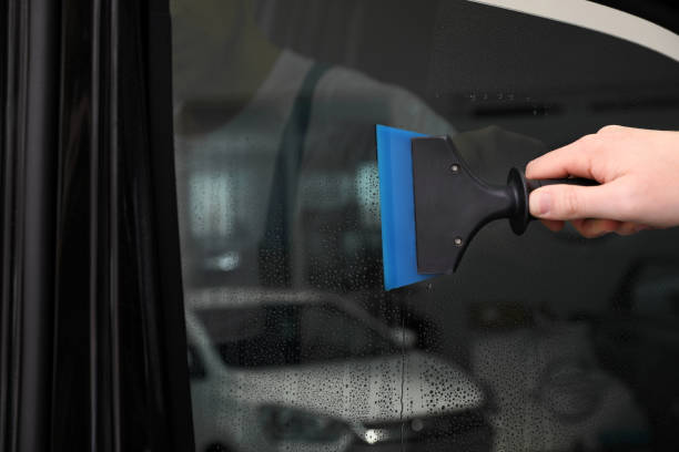 istock Worker washing tinted car window in workshop, closeup 1337869865