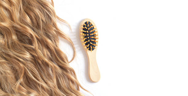 istock Long blond wavy hair and brush isolated on white 1337869902