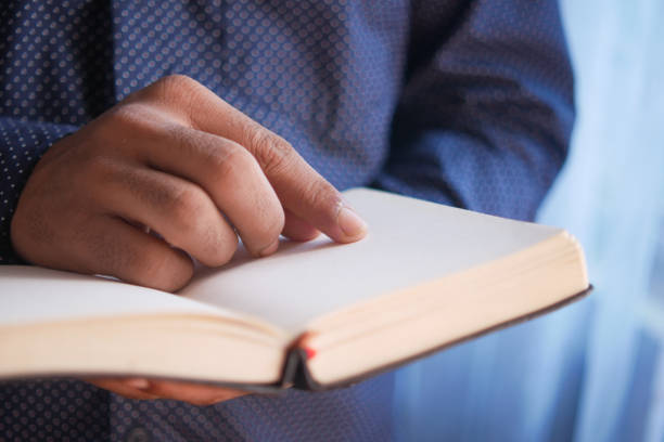 istock close up of young man hand reading a book 1337870672