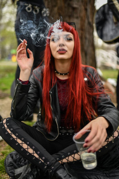 istock Elegant Gothic Female Drinking And Smoking Cigarette In Park 1337874088