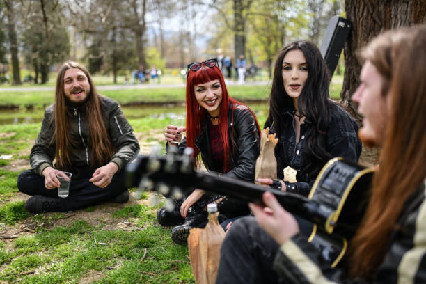 happy gothic friends appréciant de boire dans le parc avec de la musique de guitare - hard liquor photos et images de collection