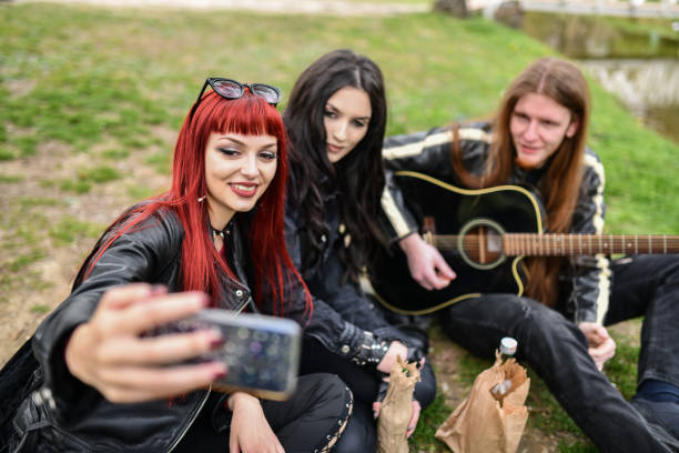 selfie mignon par des femmes gothiques et un guitariste masculin buvant dans le parc - hard liquor photos et images de collection