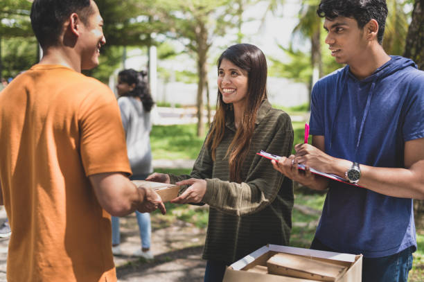 des bénévoles distribuant gratuitement des paquets de nourriture pendant la collecte de charité de la banque alimentaire communautaire à l’extérieur. - societal photos et images de collection