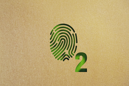 Oxygen symbol made of cut out fingerprint on green background. Horizontal composition with copy space. Sustainability concept.