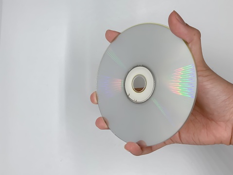 The back of the CD with a hand holding it.
