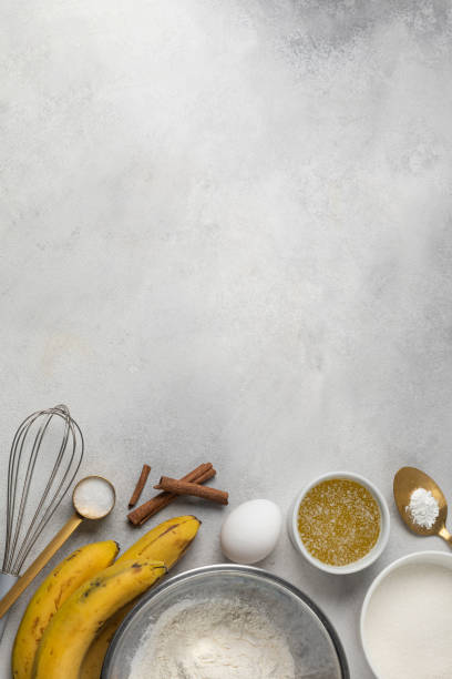 Ingredients for banana bread in bowls on light gray background top view