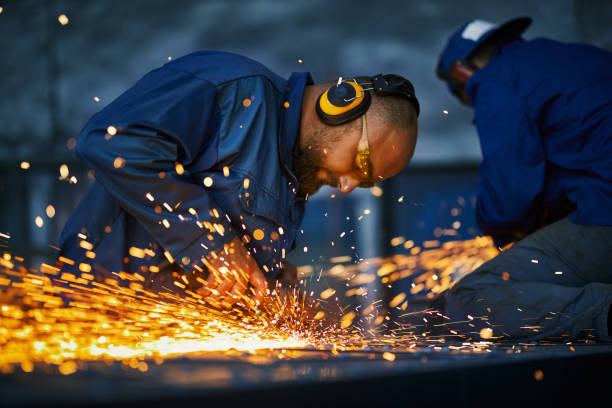 istock Two craftsmen in protective uniform welding metal 1337883563