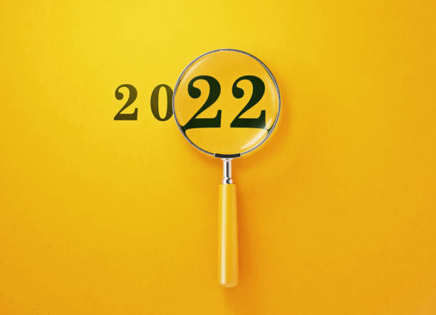 lupa e 2022 em fundo amarelo - scrutiny analyzing finance data - fotografias e filmes do acervo
