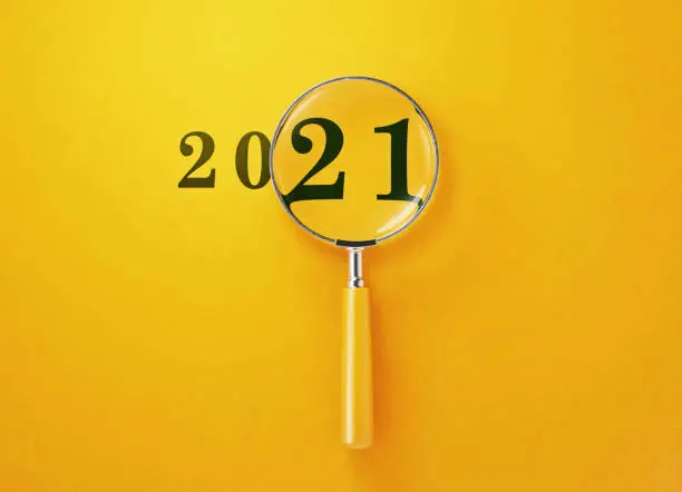 Magnifier and 2021 on yellow background. Horizontal composition with copy space.