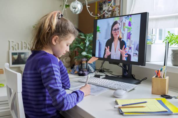 niña estudiando con el maestro de forma remota en la computadora usando videollamada - maestro particular fotografías e imágenes de stock