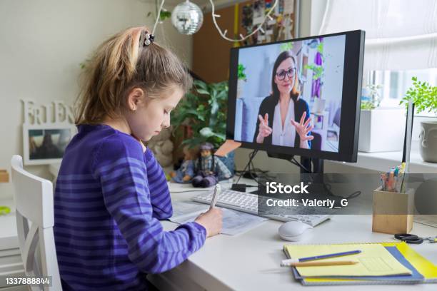 Child Girl Studying With Teacher Remotely On Computer Using Video Call Stock Photo - Download Image Now