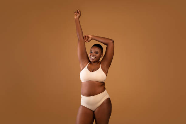 retrato de una hermosa mujer afroamericana de talla grande que muestra las axilas - laser waxing human skin beauty fotografías e imágenes de stock