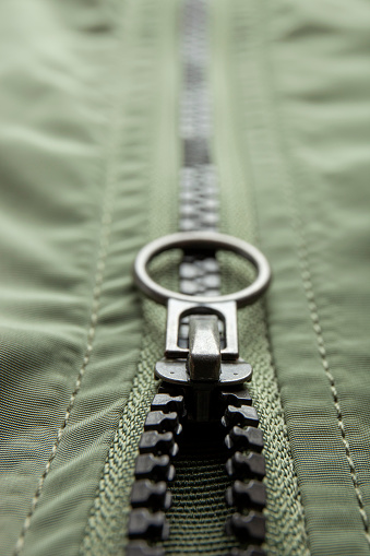 Metal zipper on nylon texture, closeup or macro view. Fastener on jacket