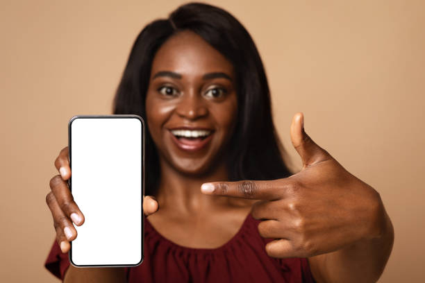 istock Closeup of black woman pointing at smartphone with empty screen 1337897600