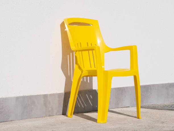 istock Yellow plastic chair near grey wall. 1337899402