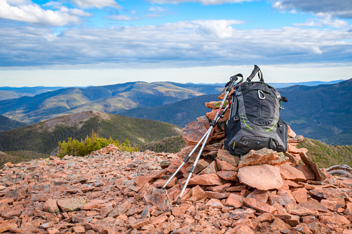 Backpack leaning on a cairn of stones at the top of Vallières-de-Saint-Réal mountains, Gaspésie, Quebec, Canada
