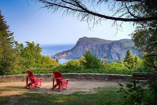 Point of view over Forillon national park at dusk, two empty adirondack chairs, Gaspésie, QC, Canada