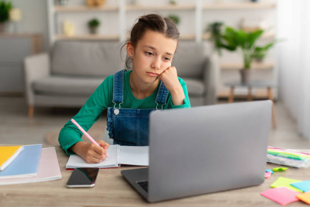 istock Tired school girl writing in notebook doing homework 1337906986