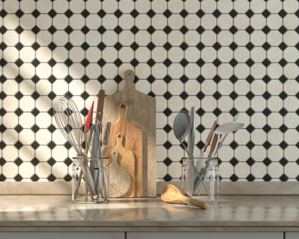 istock Front view kitchen with marble kitchen countertop cutlery set and chopping boards on it under warm morning sunshine, ceramic small diamond tiles wall, 3d Rendering 1337907479
